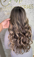 Morena iluminada com mechas e ondas longas